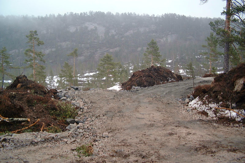 de Trollhytta wordt opgetrokken vlak achter de berg opgegraven grond in het midden van de foto